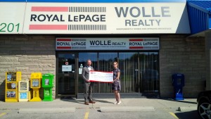 Mark Wolle, Broker of Record, Royal Le Page Wolle Realty, presents a donation cheque to Kourtney Beckman of Women's Crisis Services for $10,091 in support of Anselma House.